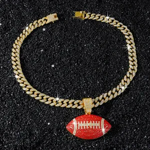 Détail d'une chaîne cubaine dorée avec un pendentif de football américain rouge brillant.