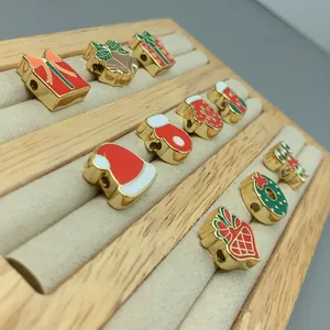 Close-up of Christmas themed enamel beads like Santa hats and stockings on a display tray