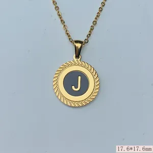 Detail eines runden Anhängers aus goldenem Edelstahl mit graviertem Buchstaben J.