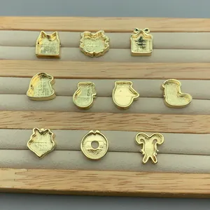 Detailed view of gold-finished Christmas themed jewelry charms on a display tray
