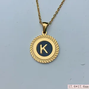 Nahaufnahme eines goldenen Edelstahl-Anhängers mit geflochtenem Rand und Buchstabe K