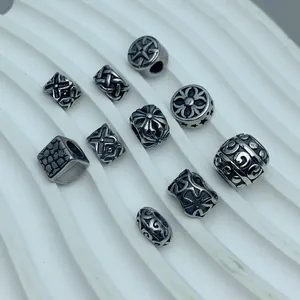 Detailed view of antique silver stainless steel spacer beads with gothic cross patterns