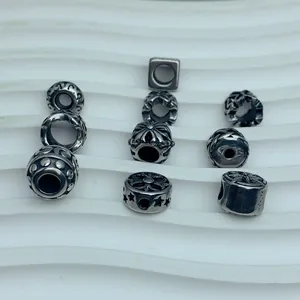 Detailed view of vintage stainless steel beads with star and floral cross patterns for DIY
