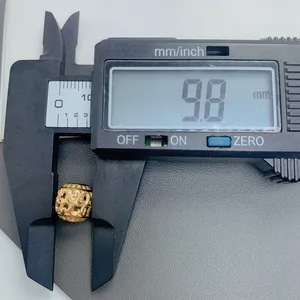 Detail view showing a 9.8mm vintage gold hollow spacer bead measured with a digital caliper.