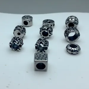 Detailed view of various vintage stainless steel spacer beads for DIY jewelry.