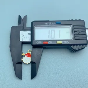 Close-up detail of a mini Santa Claus charm being measured at 10.1mm with a digital caliper