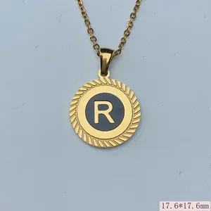 Detailansicht eines runden Gold-Edelstahlanhängers mit Buchstabe R und strukturiertem Rand