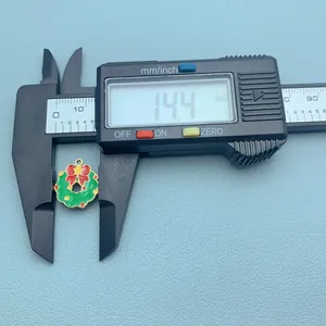 Digital caliper measuring a colorful Christmas wreath charm pendant for DIY jewelry