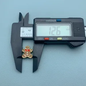 Gros plan d'une breloque bonhomme pain d'épices de 12,6 mm avec pied à coulisse
