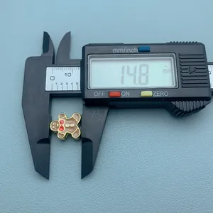 Vue détaillée d'une perle de bonhomme de pain d'épice mesurée par un pied à coulisse, 14,8 mm.