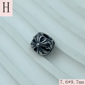 Detailed close-up view of vintage silver stainless steel bead with intricate cross engraving