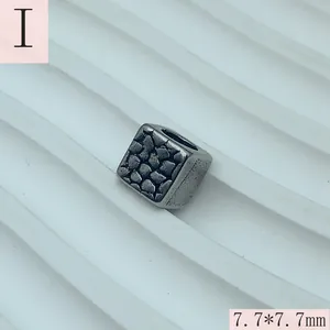 Detail view of a vintage textured square spacer bead for jewelry making, 7.7mm size.