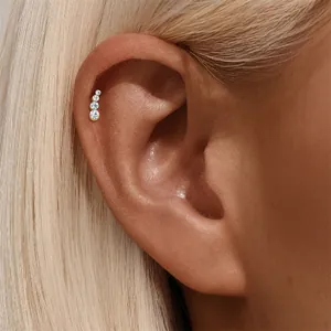Dettaglio ravvicinato di un piercing a cerchio in argento S925 con cristalli sull'orecchio.