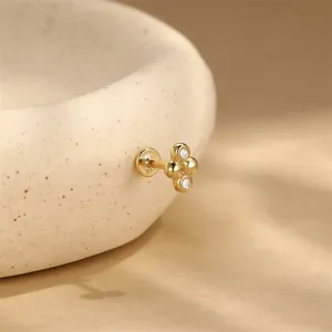Dettaglio macro di un piercing in argento S925 placcato oro 16G con piccoli zirconi