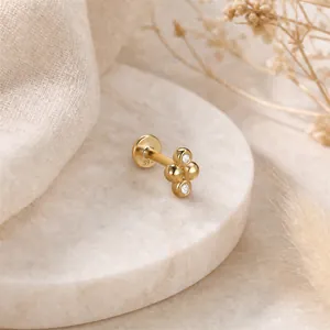 Dettaglio macro di piercing labret in argento S925 dorato 16G con cluster di perle CZ