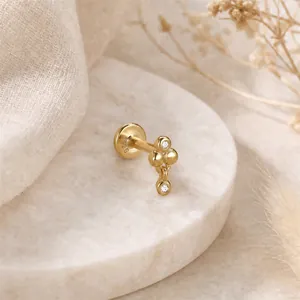 Dettaglio di orecchino a bottone in argento S925 dorato con sfere geometriche e CZ