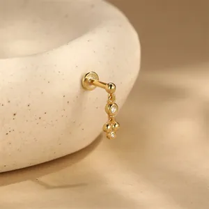 Dettaglio macro dell'orecchino per cartilagine in argento 925 dorato con zirconi