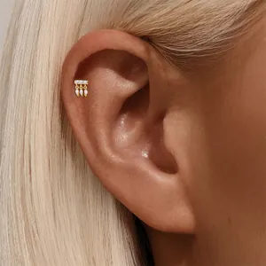 Dettaglio di un orecchino piercing in oro con zirconi marquise sulla cartilagine