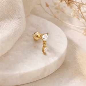Dettaglio piercing orecchio 16G con zirconi a cuore e marquise in finitura dorata