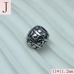 Close-up of stainless steel spacer bead with swirl and dot patterns for DIY jewelry