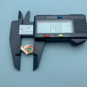Gros plan d'un charm de Noël en émail de 14,8 mm mesuré avec un pied à coulisse digital