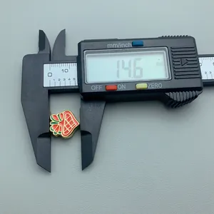 Detailed measurement of a red Christmas enamel charm at 14.6mm with a digital caliper