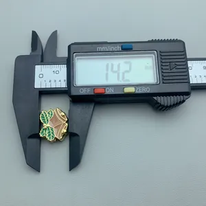 Close-up of a festive Christmas bell bead charm with 14.2mm digital caliper measurement