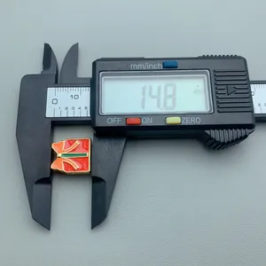 Detailed measurement of red Christmas gift box enamel bead showing 14.8mm width in caliper