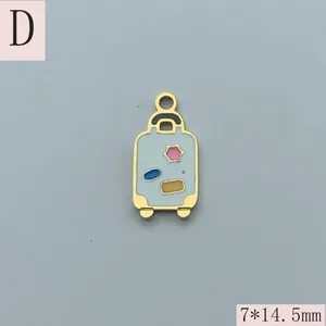 Detailed view of gold-plated enamel suitcase charm measuring 7 by 14.5mm