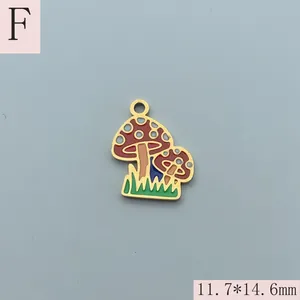 Detail view of a 11.7x14.6mm red enamel mushroom charm in gold-plated stainless steel.