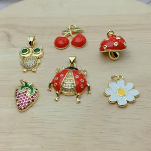 Vista detallada de dijes de circonita de mariquita, cereza y flores para joyería.