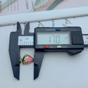 Detalle de un colgante de fresa con circonitas medido con un calibre digital de precisión.