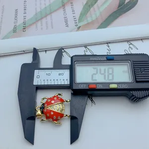 Vista detallada que muestra el tamaño del colgante de mariquita medido a 24,8 mm con un calibre
