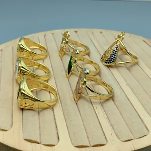 Detailansicht goldener verstellbarer Ringe mit religiösen Motiven auf Display-Tablett.