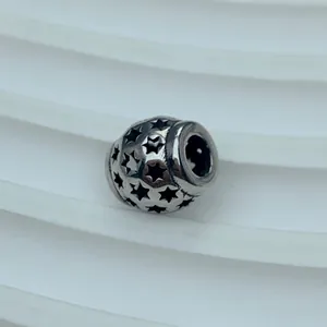 Detailansicht einer Titanstahl-Zwischenperle mit dekorativen Stern-Ausschnitten.