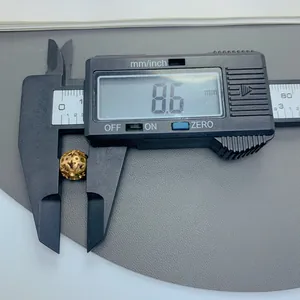 Nahaufnahme einer goldenen Titanstahlperle mit Sternmuster, 8,6 mm mit Messschieber