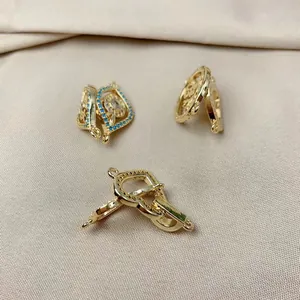 Detailed view of gold-tone heart and evil eye pendants for DIY jewelry making.