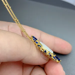 Seitenansicht der Goldkette mit Anhänger aus weißer Perlmutt und blauen Edelsteinen