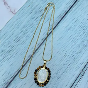 Macro detail of the Our Lady of Guadalupe pendant with mother of pearl and tiger eye stones