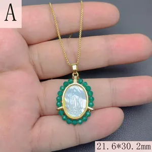 Detail view of Our Lady of Guadalupe pendant with mother of pearl inlay and green beads