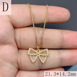 Vista detallada del collar con colgante de lazo dorado e incrustaciones de nácar 21,3x14,2mm