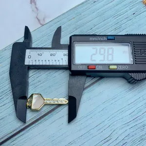 Medición detallada de las dimensiones de un colgante de llave de oro con nácar, 29,8mm