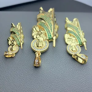 Close-up of Saint Jude gold-plated pendants with micro-paved green cubic zirconia