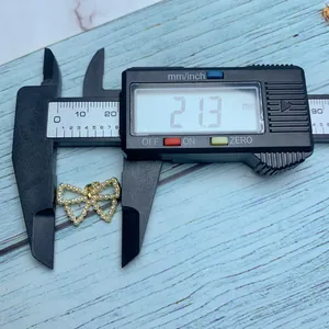 Vista detallada que muestra el ancho de 21,3 mm del elegante colgante de lazo con perlas y calibre
