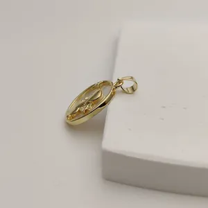 Detailed view of a gold praying angel pendant with white mother-of-pearl inlay