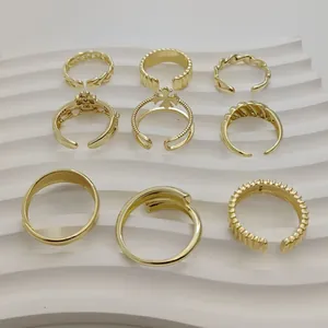 Detailweergave van negen verschillende minimalistische gouden ringen op een wit display