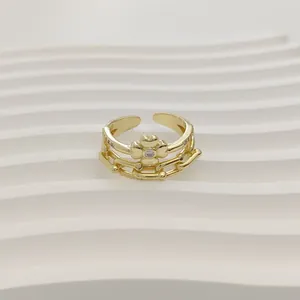 Detailopname van verstelbare gouden kroonring met klavermotief en steeninleg