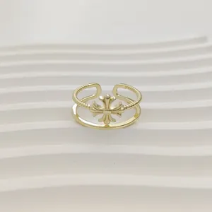 Gedetailleerde weergave van een gouden ring met dubbele band en centraal bloemkruismotief