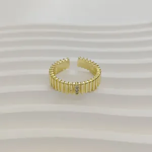 Detailweergave van een elegante gouden geribbelde open ring met klein kristalelement