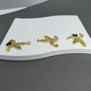 Makroansicht von drei goldenen Vogelanhängern mit Zirkonia und farbigen Steinen für DIY-Schmuck
